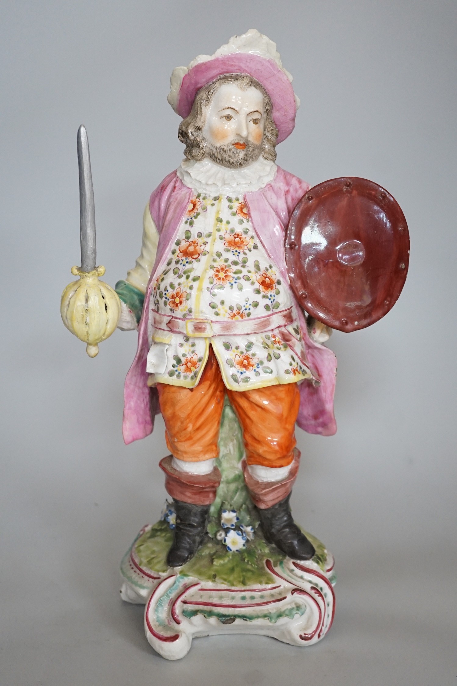 A large Derby figure of Falstaff standing, holding a sword and shield, patch marks, original brass sword, is now a modelled replacement, 39cms high